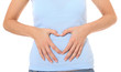 Weibliche Person formt ein Herz auf ihrem Bauch