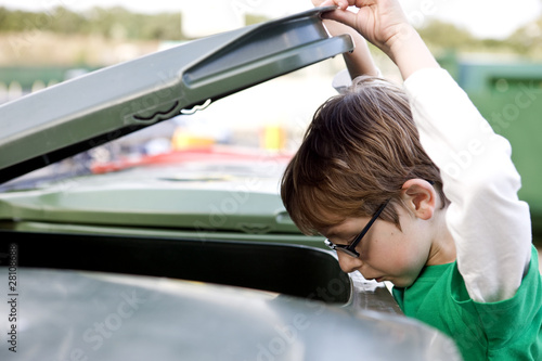 Photo: A young boy looking into a recycling bin A young boy looking into a recycling bin