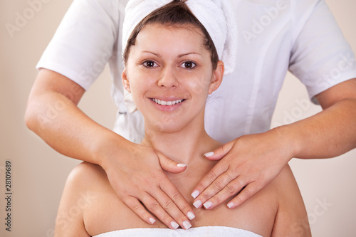 Photo: Young beautiful woman getting shoulders massage Young beautiful woman getting shoulders massage