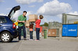 A father and children recycling cardboard boxes
