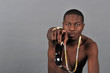 African American man on a grey background pointing ahead.