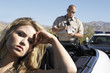Police officer ticketing women sitting in car