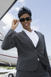 Photo: Mid-adult businesswoman in sunglasses standing in front of private plane, low angle view. Mid-adult businesswoman in sunglasses standing in front of private plane, low angle view.