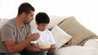 Vídeo: Father and son speaking while watching television at home Father and son speaking while watching television at home