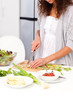 Close up of a woman cutting vegetables in the kitchen