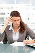 Concentrated businesswoman taking notes while working on laptop