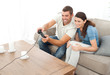 Attentive couple playing video game together in the living room Attentive couple playing video game together in the living room