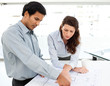 Two serious architects looking at blueprints on a table