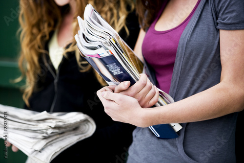 Photo: Two teenage girls holding magazines and newspapers Two teenage girls holding magazines and newspapers