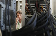 Man using phone, surrounded by computer equipment.