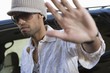 Male celebrity shielding face