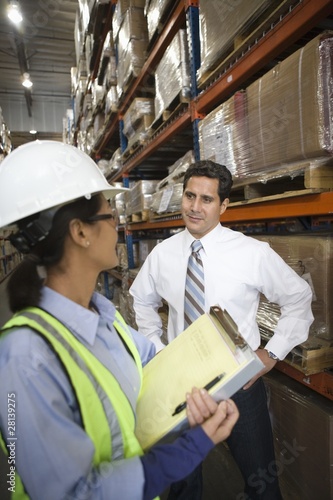 Photo: Woman and man talking in distribution warehouse Woman and man talking in distribution warehouse