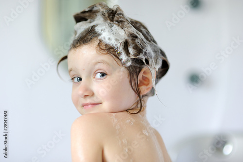 Photo: Small girl in bath with shampoo on her hair Small girl in bath with shampoo on her hair