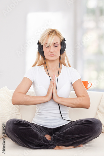 Photo: Beauty, blondie woman in a yoga position listening music Beauty, blondie woman in a yoga position listening music