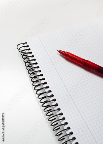 Photo: boligrafo rojo encima de un cuaderno boligrafo rojo encima de un cuaderno