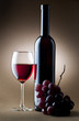 glass of red wine with bottle and cluster