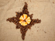 Star from coffee beans with tangerine in the center Star from coffee beans with tangerine in the center