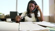 Young businesswoman working at desk and talking on phone
