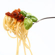 Spaghetti bolognese with basil leaves on a fork Spaghetti bolognese with basil leaves on a fork