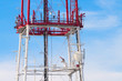 Telecommunication tower with antennas against blue sky backgroun