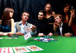 Stylish man in black suit folds two cards in casino poker