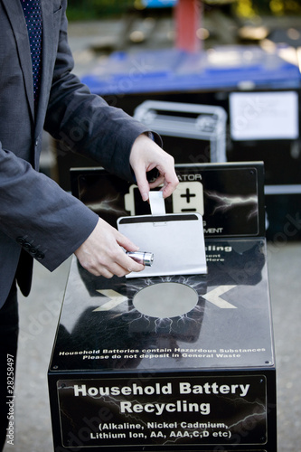 Photo: A businessman recycling household batteries A businessman recycling household batteries