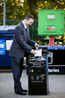 A businessman recycling household batteries