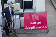 A businessman standing with a trolley in a recycling center