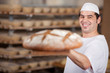 bäcker schiebt großes brot in den ofen