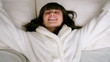 Woman falling backward onto bed, slow motion