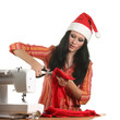 Seamstress in a christmas hat cut cloth Seamstress in a christmas hat cut cloth