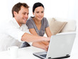 Cute man showing something on the laptop screen to his wife