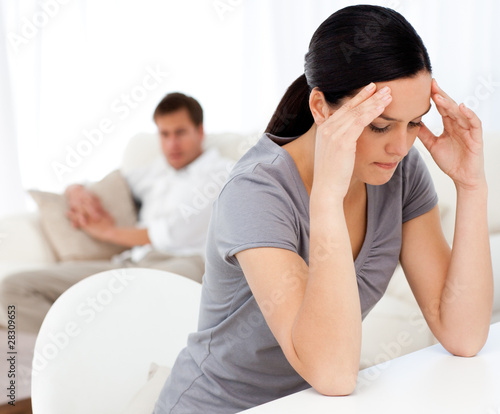 Photo : Man looking at his girlfriend having a headache sitting at a tab Man looking at his girlfriend having a headache sitting at a tab