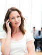 Pensive businesswoman on the phone while her team is working Pensive businesswoman on the phone while her team is working