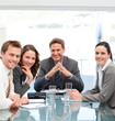 Portrait of a positive manager with his team sitting at a table