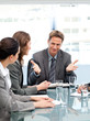 Happy manager talking to his team sitting at a table Happy manager talking to his team sitting at a table