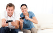 Excited woman playing video games with her boyfriend on the sofa Excited woman playing video games with her boyfriend on the sofa