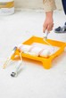Photo: worker dipping paint roller. home renovation theme. worker dipping paint roller. home renovation theme.