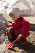 Child playing in the mud in early spring