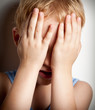 Portrait of sad crying child covers his face with hands