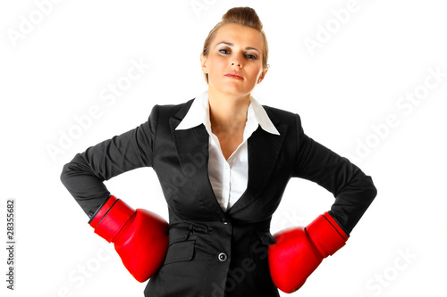 Photo: Business woman holding hands with boxing gloves on hips Business woman holding hands with boxing gloves on hips