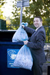 A businessman recycling bags of shredded paper