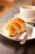 Cup of fresh coffe with croissant