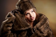 Attractive woman in brown  fur coat with hood