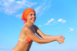 beauty woman in orange bikini and bandana playing volleyball