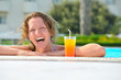 attractive woman is smiling from swimming pool in resort