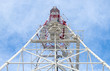 Telecommunication tower with antennas against blue sky