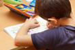 boy doing homework  with color pencil, painting fruits