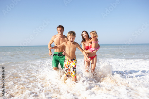 Photo: Young family play on beach Young family play on beach