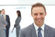 Happy businessman posing in front of his team Happy businessman posing in front of his team